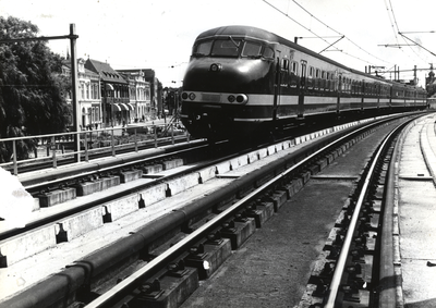 169115 Afbeelding van een electrisch treinstel mat. 1964 (plan T) van de N.S. op het viaduct van het hoogspoor door Delft.